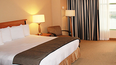 A king bed inside a suite at Hollywood Gulf Coast