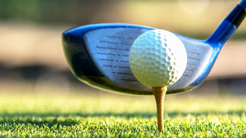 golfer lining up ball and club